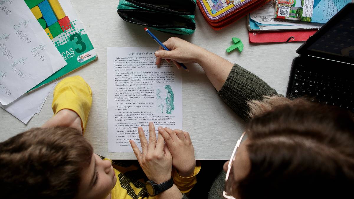 Un niño estudia y hace los deberes en casa con la ayuda de su madre. Foto: EP