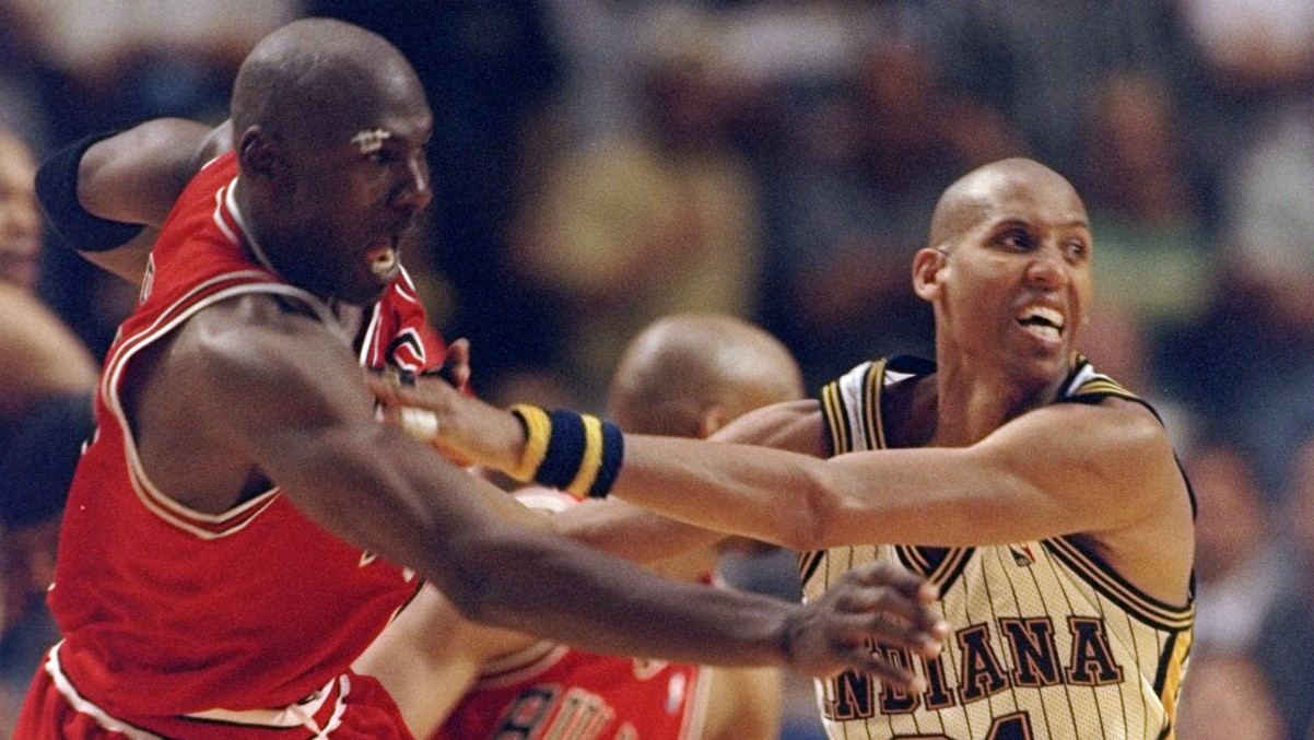 Michael Jordan y Reggie Miller luchan en un partido. (Getty)