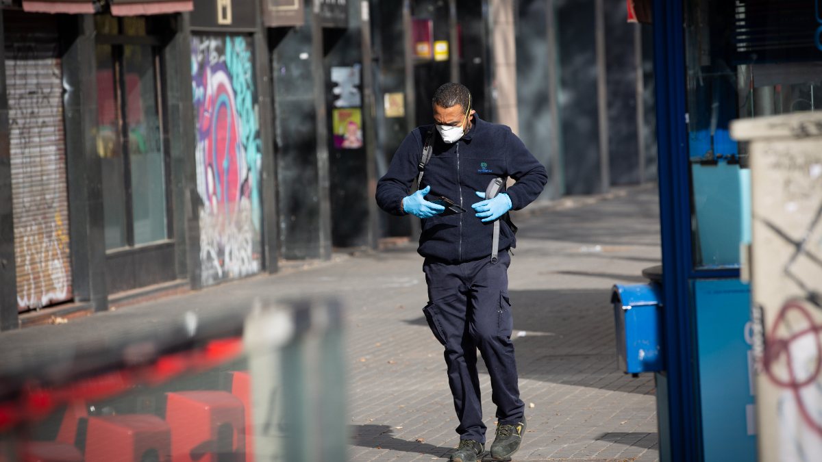 Un hombre protegido con mascarilla y guantes camina por una calle. Foto: EP