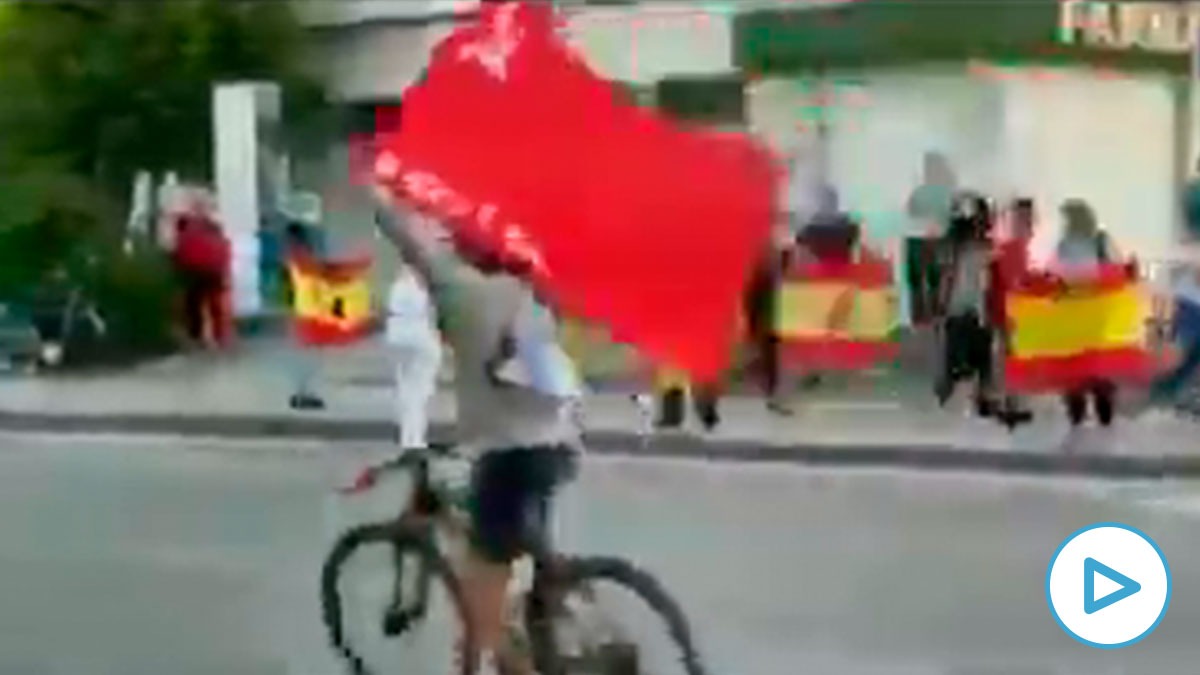 Una persona saca la bandera comunista en las protestas contra Sánchez.