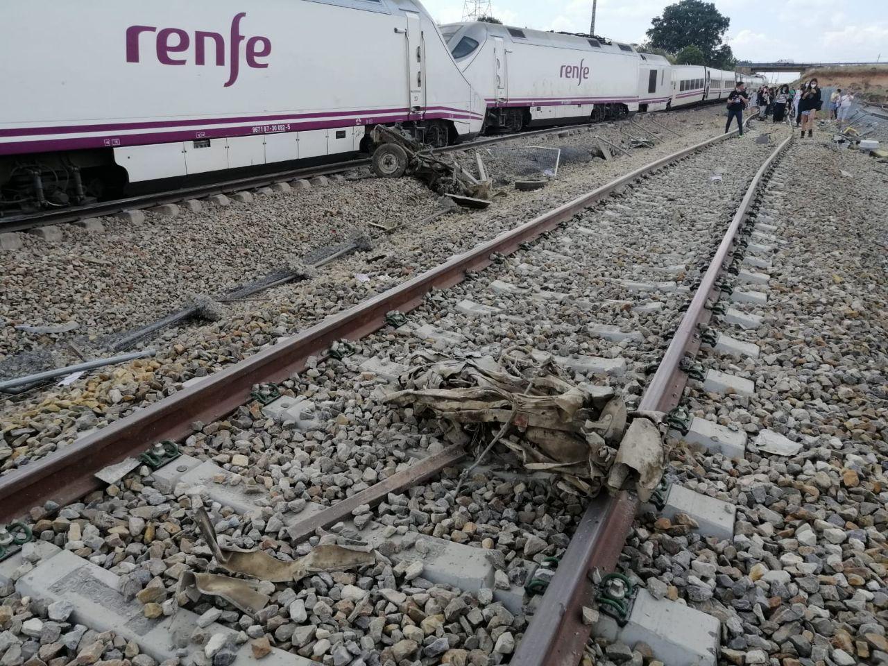 El tren Alvia accidentado con partes del coche en primer término y algunos pasajeros andando por las vías. Foto cedida