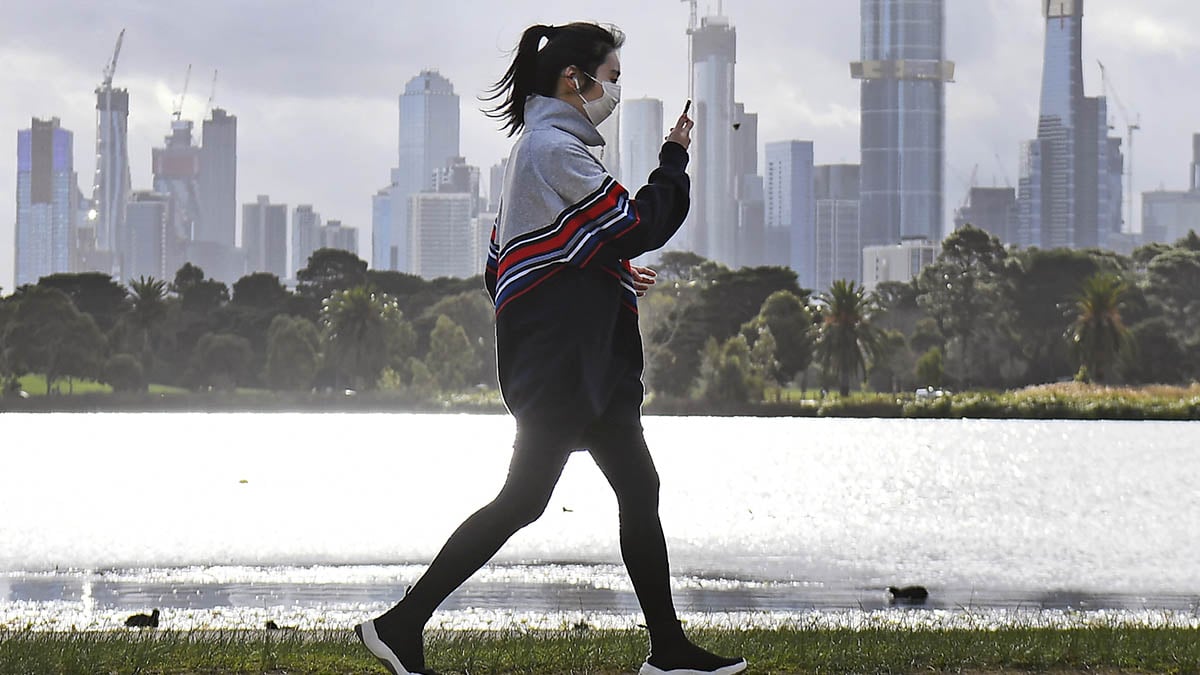 Una mujer hace ejercicio con Melbourne al fondo en plena psicosis por los rebrotes de coronavirus.