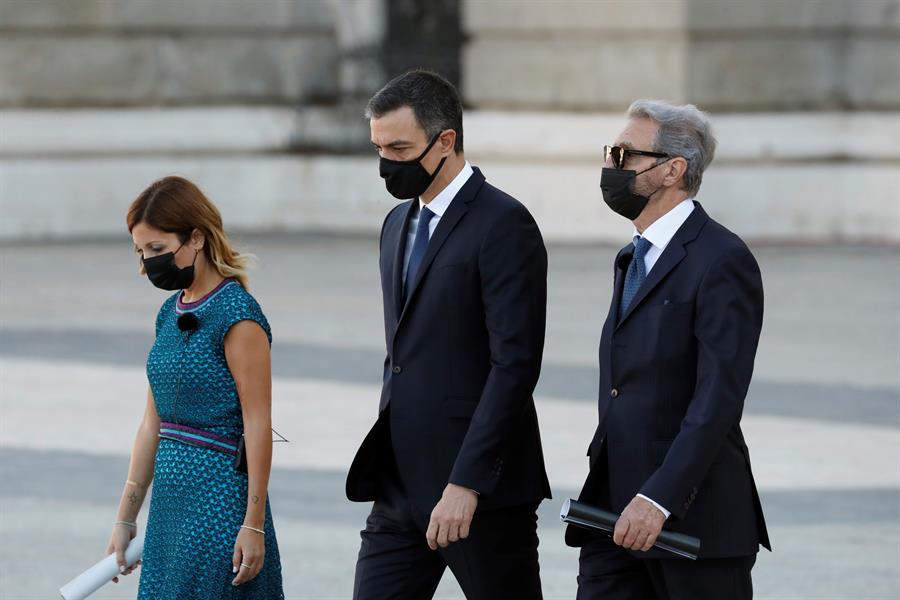 El presidente del Gobierno, Pedro Sánchez (c), junto a Hernando Calleja, hermano del periodista José Mari Calleja, fallecido durante la pandemia​, y la jefa del servicio de Urgencias del Hospital Vall d'Hebron, Aroa López, a su llegada al Patio de la Armería del Palacio Real donde se celebra este jueves el homenaje de Estado a las víctimas de la pandemia de coronavirus. Foto: EFE