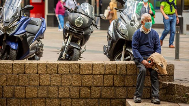 Un hombre espera protegido con mascarilla en la plaza de los Fueros de Vitoria.