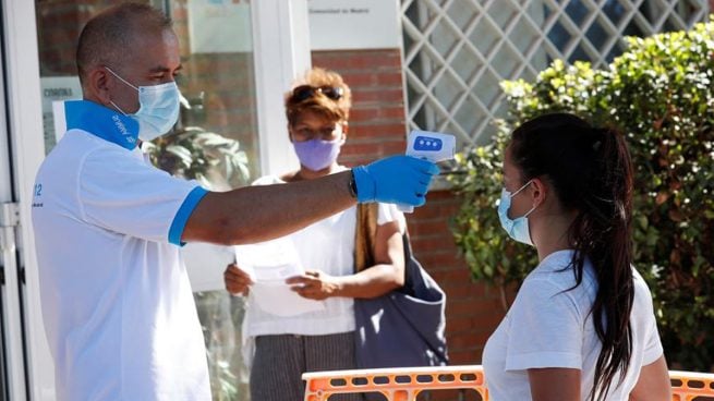 Un paramédico toma la temperatura a una ciudadana antes de acceder al centro de salud Reyes Católicos, de la localidad madrileña San Sebastián de los Reyes, durante la realización de pruebas PCR a vecinos de Alcobendas. Foto: EFE