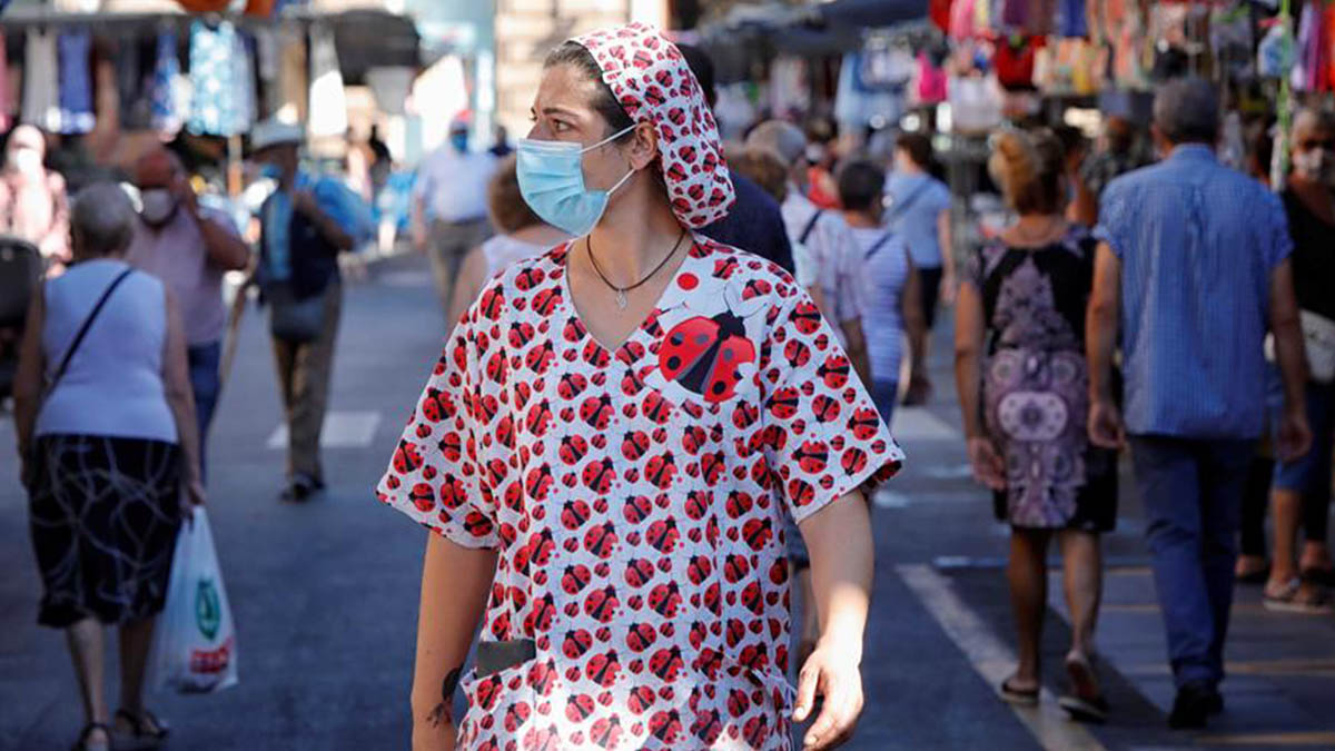 Una mujer pasea por un mercado del centro de Reus (Tarragona) donde este lunes se han reanudado los cribados masivos de PCR.
