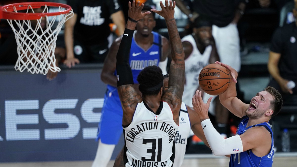 Doncic, en una entrada a canasta contra Morris. (Getty)