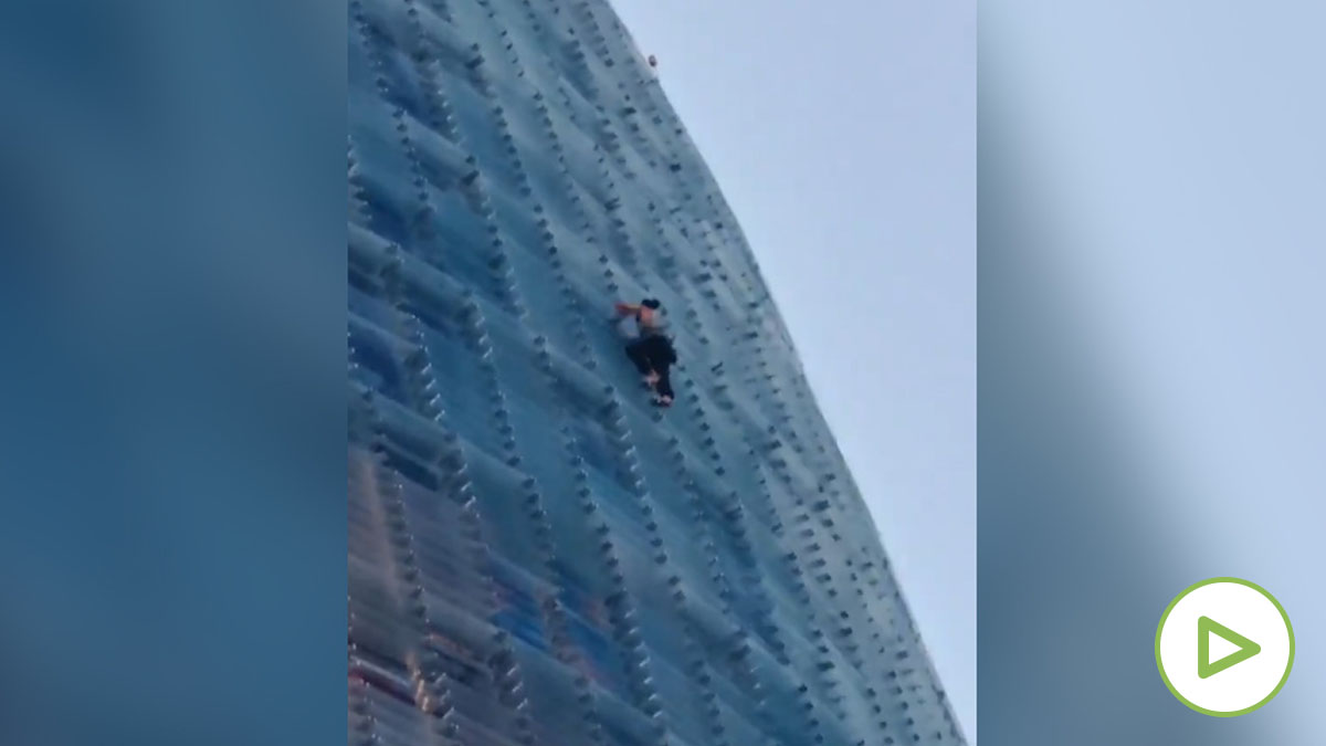 Un escalador trepa la Torre Glòries de Barcelona descalzo y sin protección.