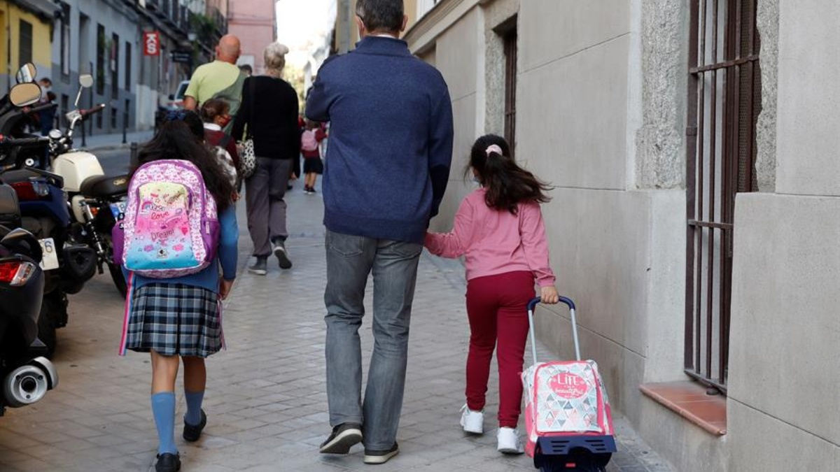 Un padre acompaña a sus hijas en la ‘vuelta al cole’ en Madrid.