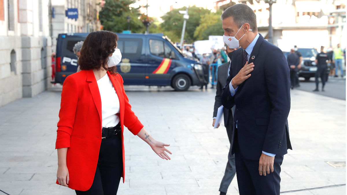 La presidenta de la Comunidad de Madrid, Isabel Díaz Ayuso, y el presidente del Gobierno, Pedro Sánchez, a las puertas de la sede del Gobierno regional, en Madrid. (Foto: Efe)