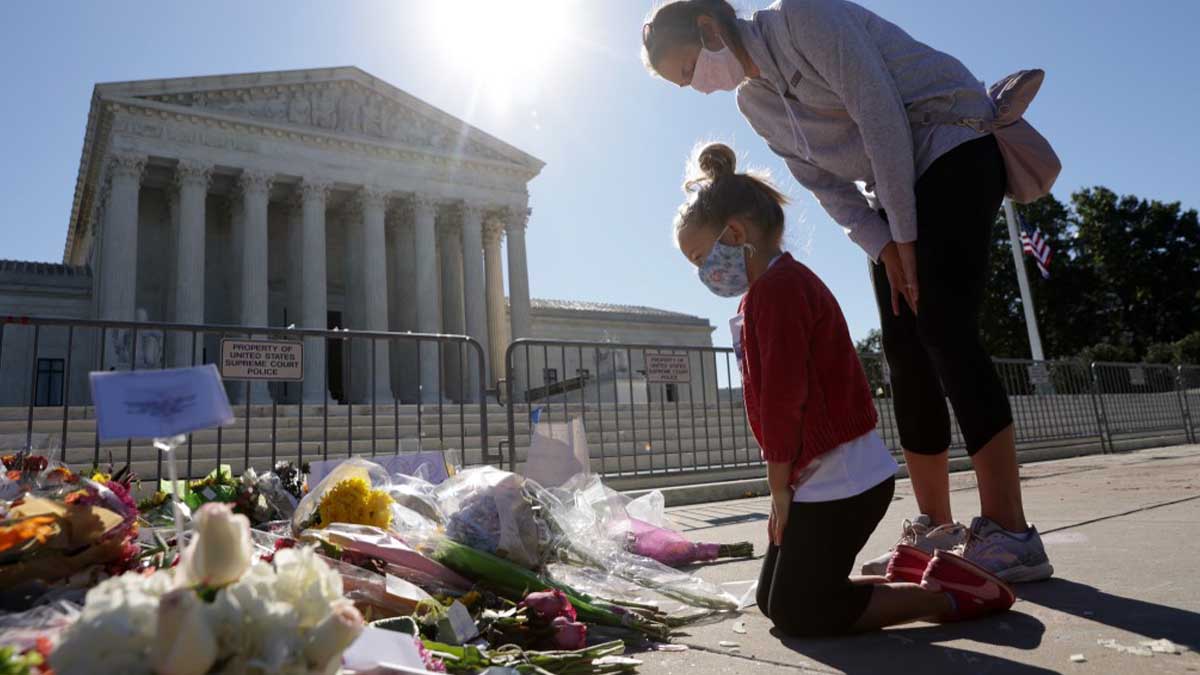 Una madre junto con su hija presentan sus respetos a la juez fallecida Ruth Bader Ginsburg frente al Tribunal Supremo de Estados Unidos. Foto: AFP