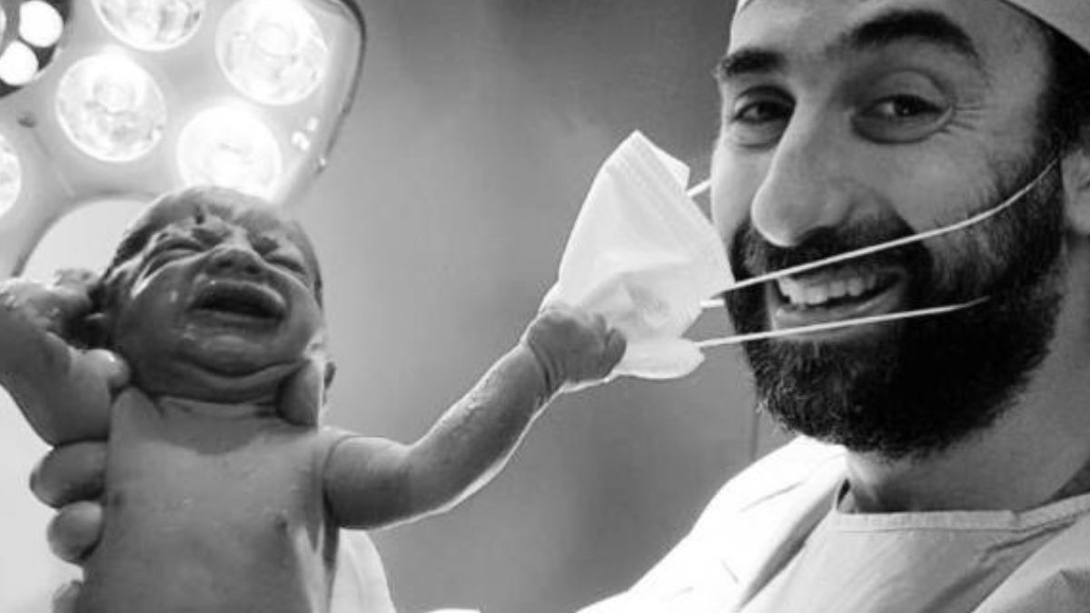 Recién nacido quitándole la mascarilla al médico