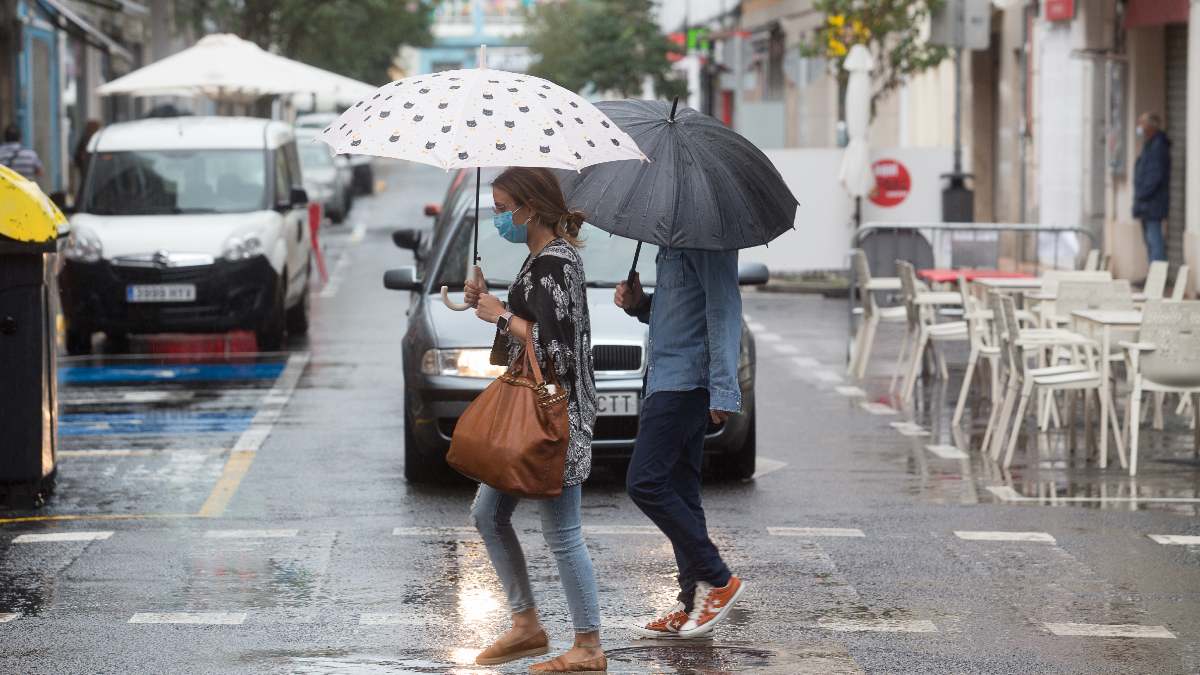 Dos jóvenes pasean bajo la lluvia. Foto: EP