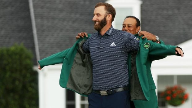 Tiger Woods le pone la legendaria chaqueta verde a Dustin Johnson.  (Getty)