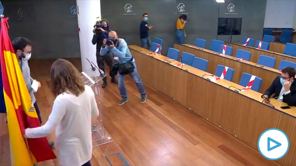 La diputada de la CUP Mireia Vehí apartando la bandera de España en la sala de prensa del Congreso.