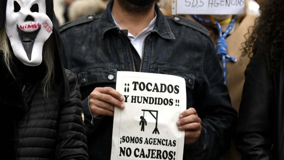 Trabajadores del sector de las agencias se concentran con caretas similares a la del film ‘Scary movie’ y carteles reivindicativos frente al Congreso de los Diputados, en Madrid (España)