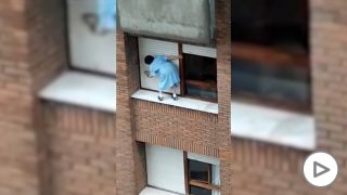 Una mujer de Gijón sube a la ventana de un séptimo piso para limpiar la persiana