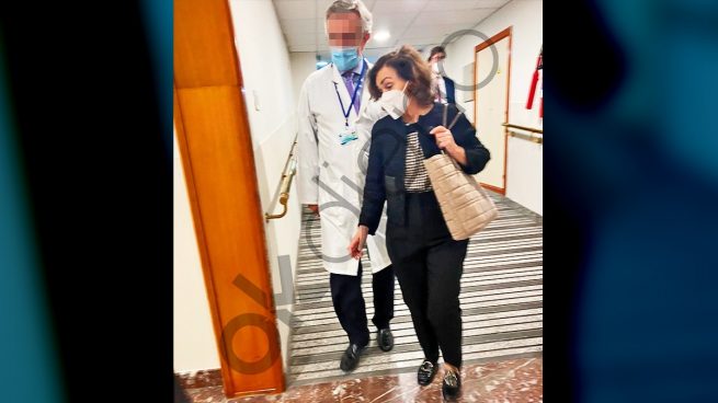 Carmen Calvo, con el médico de La Moncloa detrás, este martes en los pasillos del hospital San Francisco de Asís de Madrid.