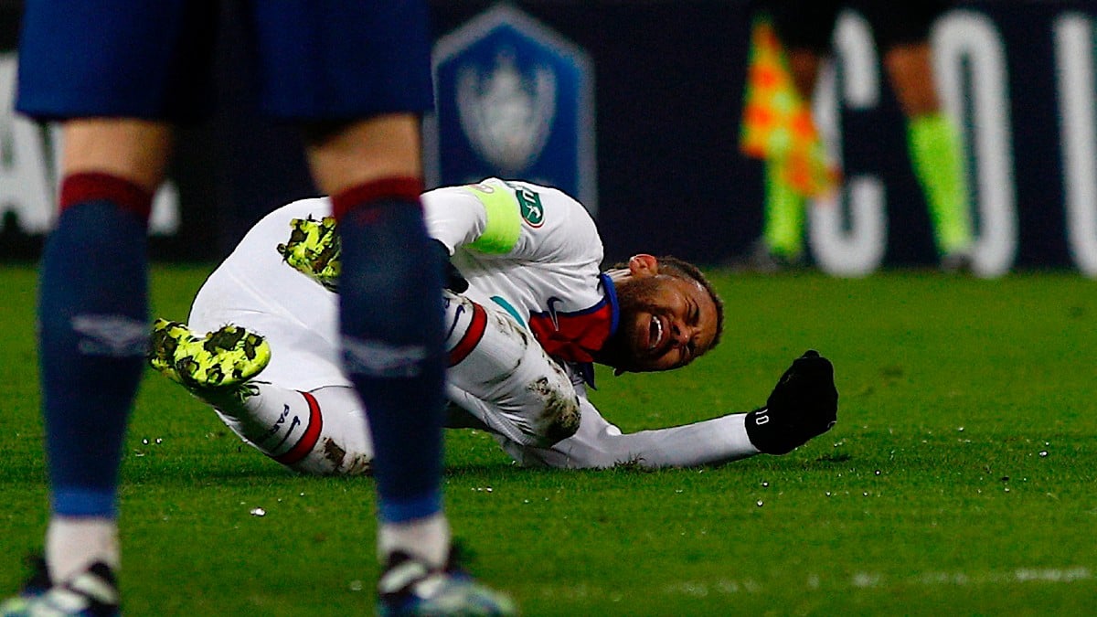 Neymar se duele en el partido contra el Caen. (AFP)