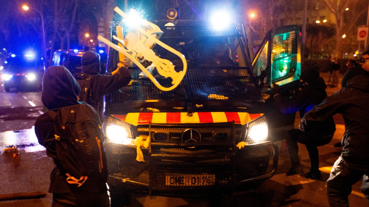 Varios manifestantes lanzan objetos a un vehículo de los cuerpos antidisturbios tras la manifestación de protesta por la detención del rapero Pablo Hasel, condenado por delitos de enaltecimiento del terrorismo e injurias a la Corona. (Foto: Efe)