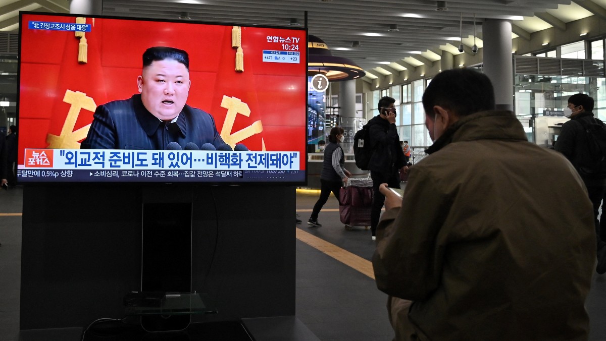 Un ciudadano sigue la comparecencia de Kim Jong-Un. (AFP)