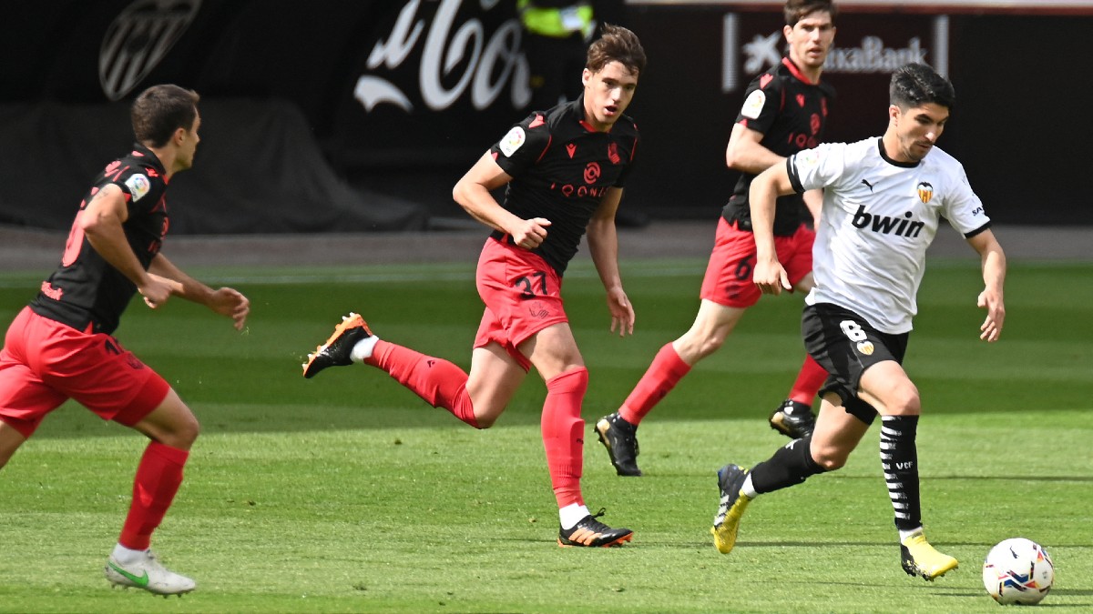 Los jugadores del Valencia y Real Sociedad pelean por un balón. (AFP)