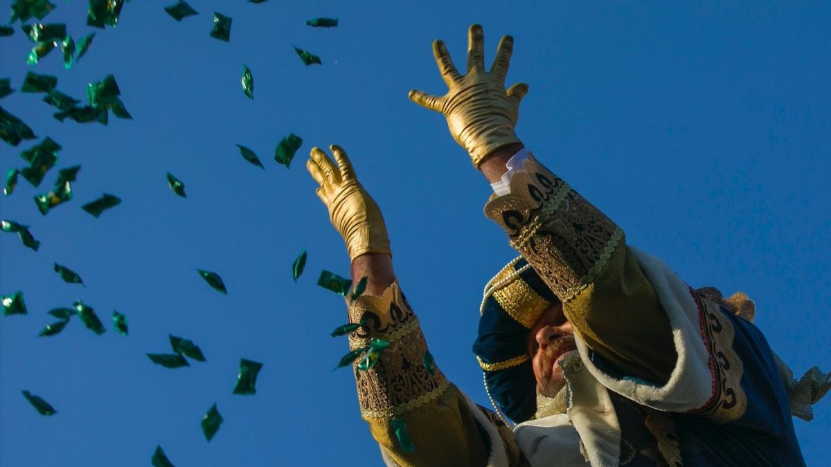 El Rey Melchor lanza caramelos durante la cabalgata de los Reyes Magos en Sevilla en 2020 (María José López / Europa Press)