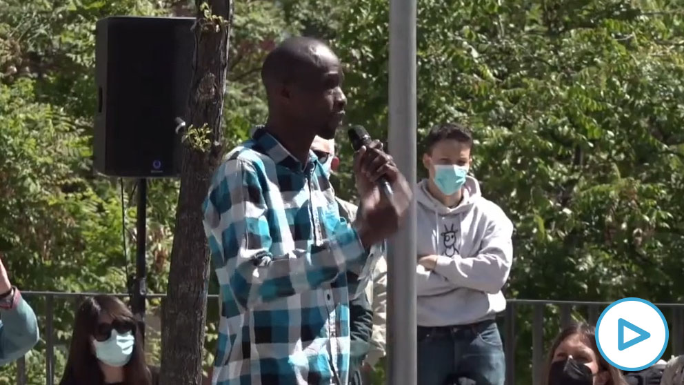 Serigne Mbaye en el acto de campaña de Podemos, con Pablo Iglesias al fondo. (Foto: EP)