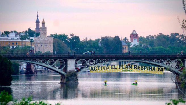 Greenpeace cuelga una pancarta del Puente de Triana para pedir el Plan Respira: «Espadas, no seas malaje»
