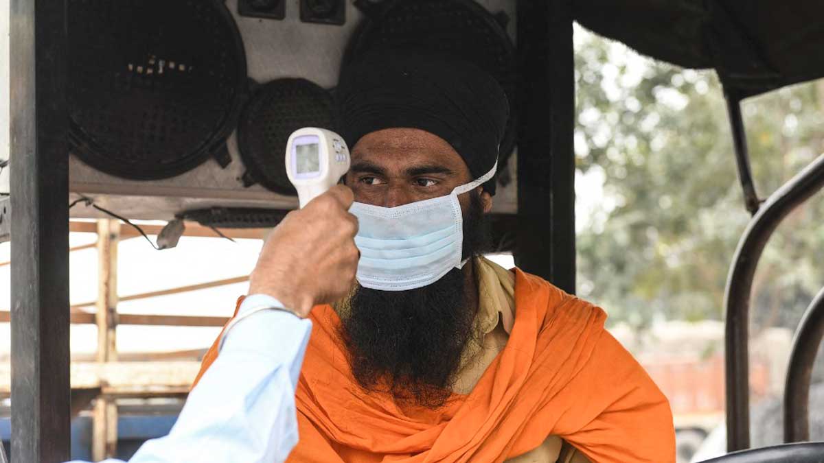 Un sanitario toma la temperatura a un conductor en Amritsar, India. Foto: AFP