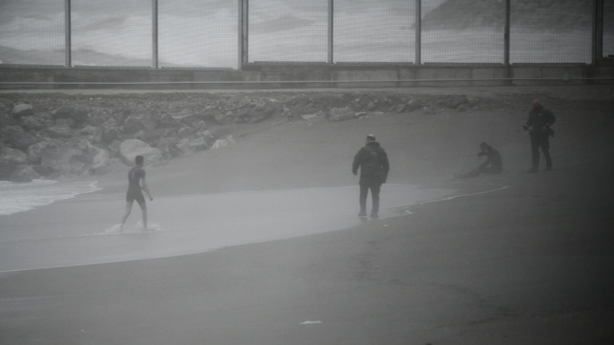 Dos jóvenes migrantes marroquíes llegan a la playa del Tarajal de Ceuta
