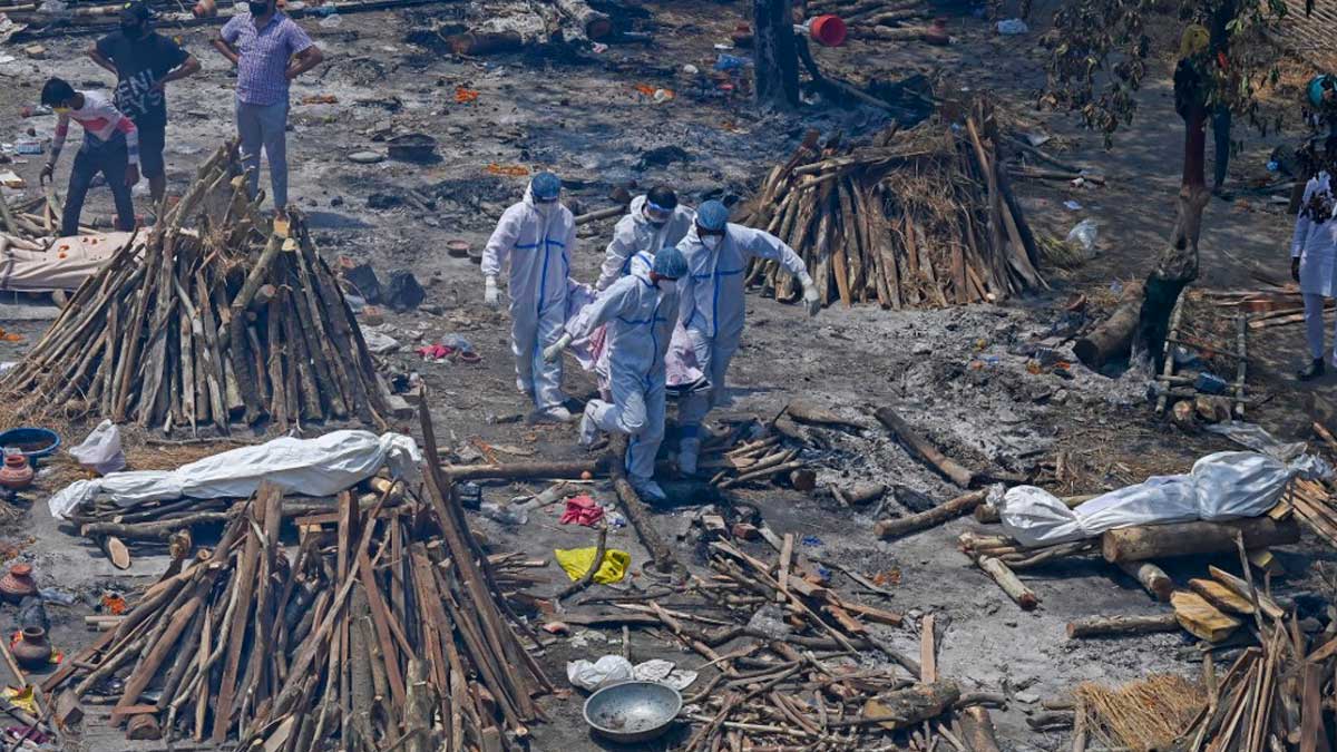 Trabajadores sanitarios recogen cadáveres de un hospital que ardió con cientos de enfermos Covid en su interior en India. Foto: AFP