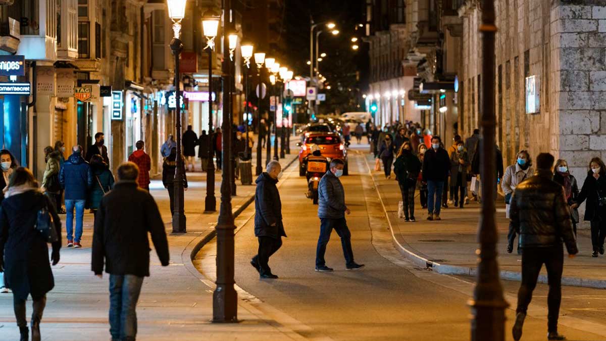 Personas paseando por una calle de Burgos por la noche. Foto: AFP