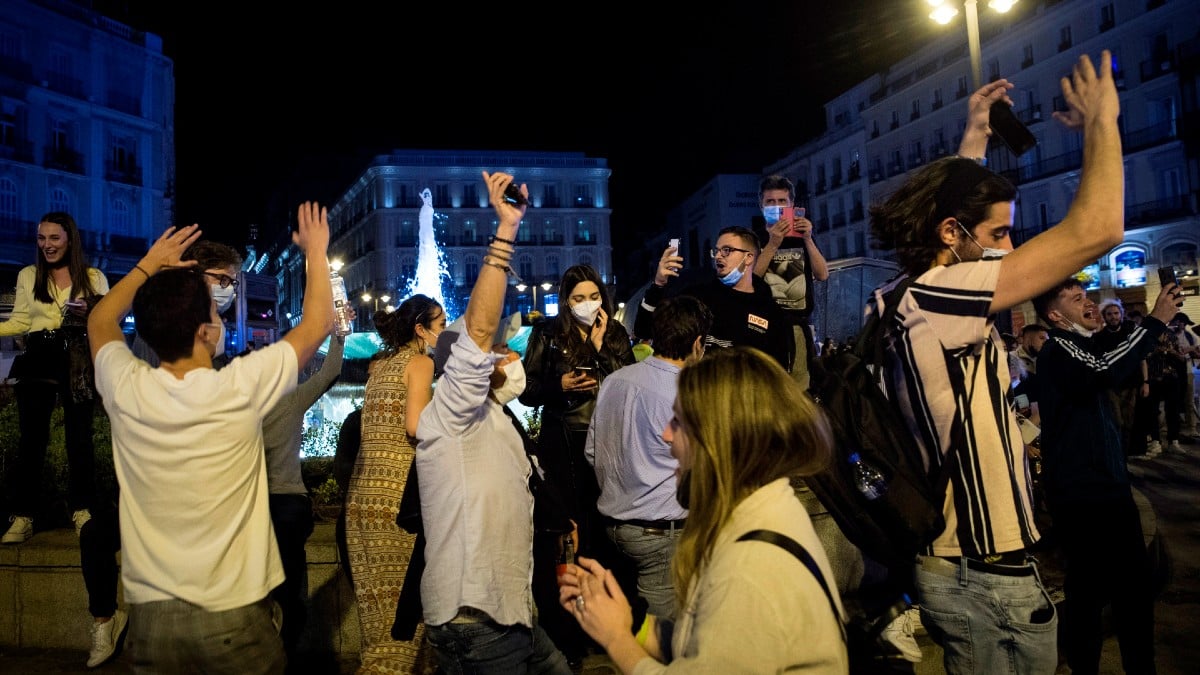 Un grupo de personas celebra el final del estado de alarma en la Puerta del Sol de Madrid.