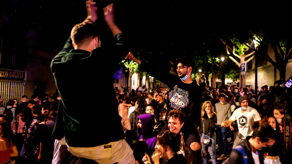 Decenas de jóvenes celebran junto al Passeig de Lluis Companys de Barcelona, el fin del estado de alarma en Cataluña durante la madrugada del domingo. (Foto: Efe)