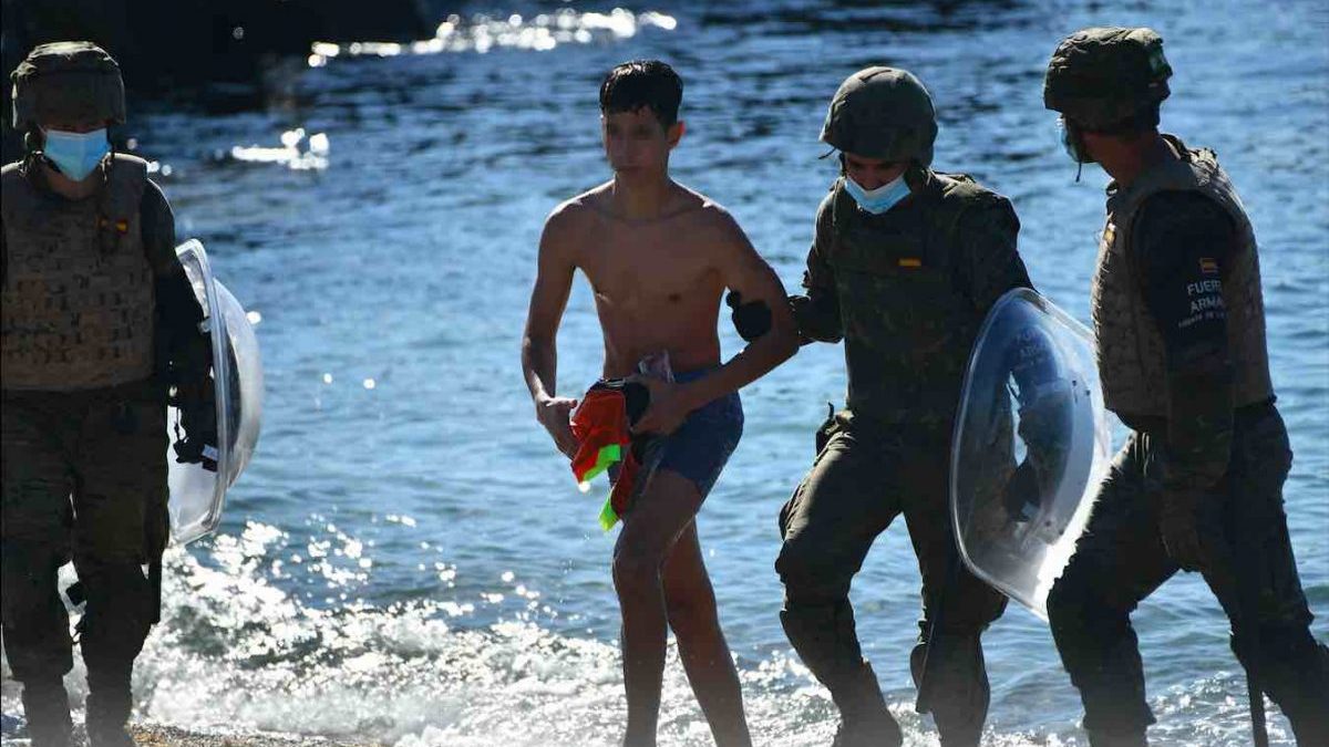 Militares del ejército español ayudan a un mena llegado a Ceuta desde Marruecos.