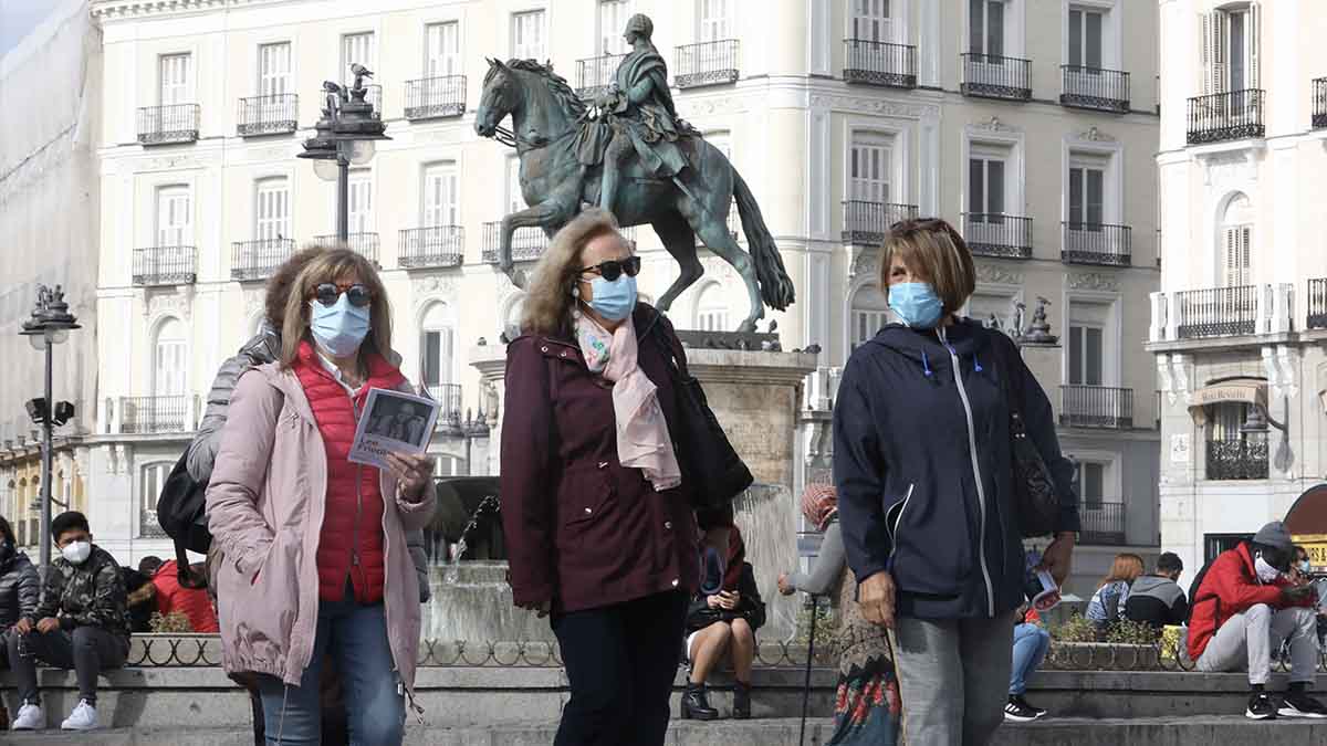 Transeúntes caminan por las inmediaciones de la Puerta del Sol. Foto: EP