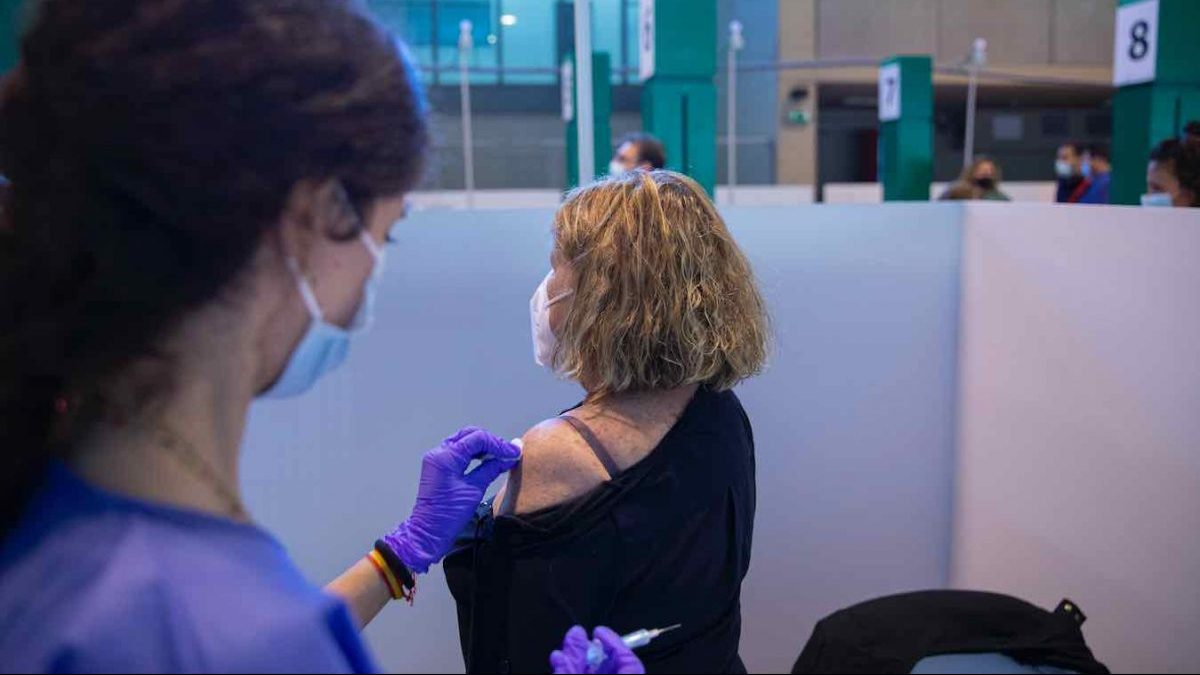 Una sanitaria vacuna a una mujer contra el Covid-19 en La Cartuja de Sevilla (María José López / Europa Press).
