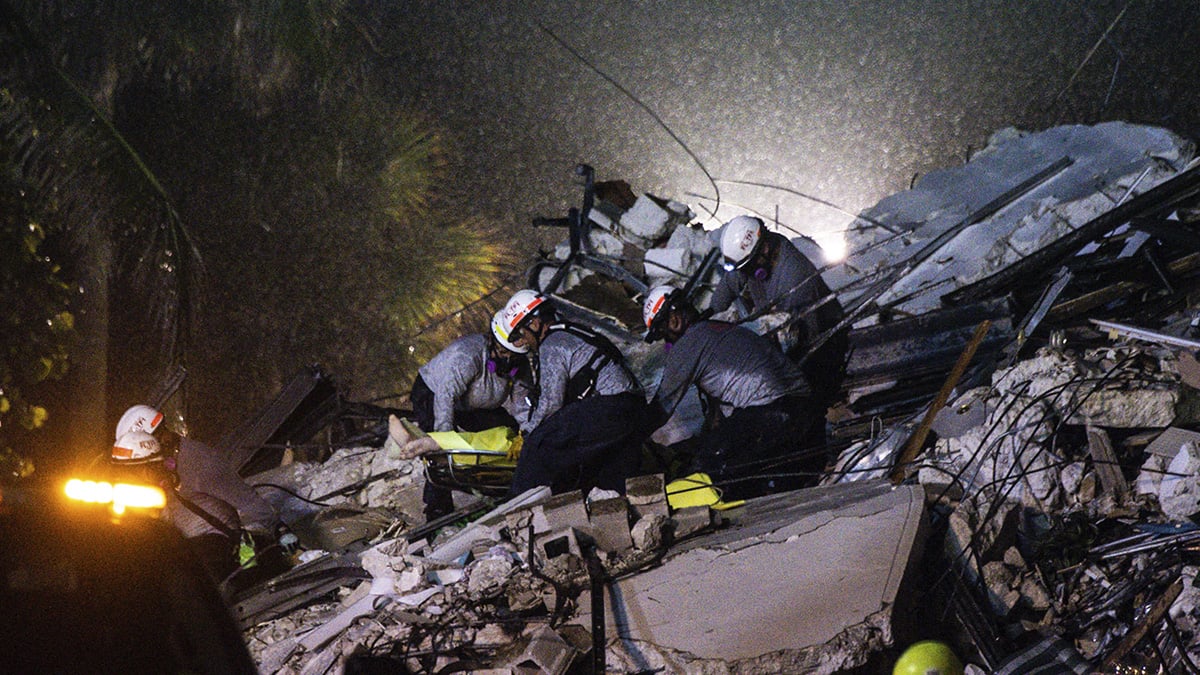 Equipos de rescate retiran un cuerpo entre los escombros del edificio derrumbado en Miami. (AFP)