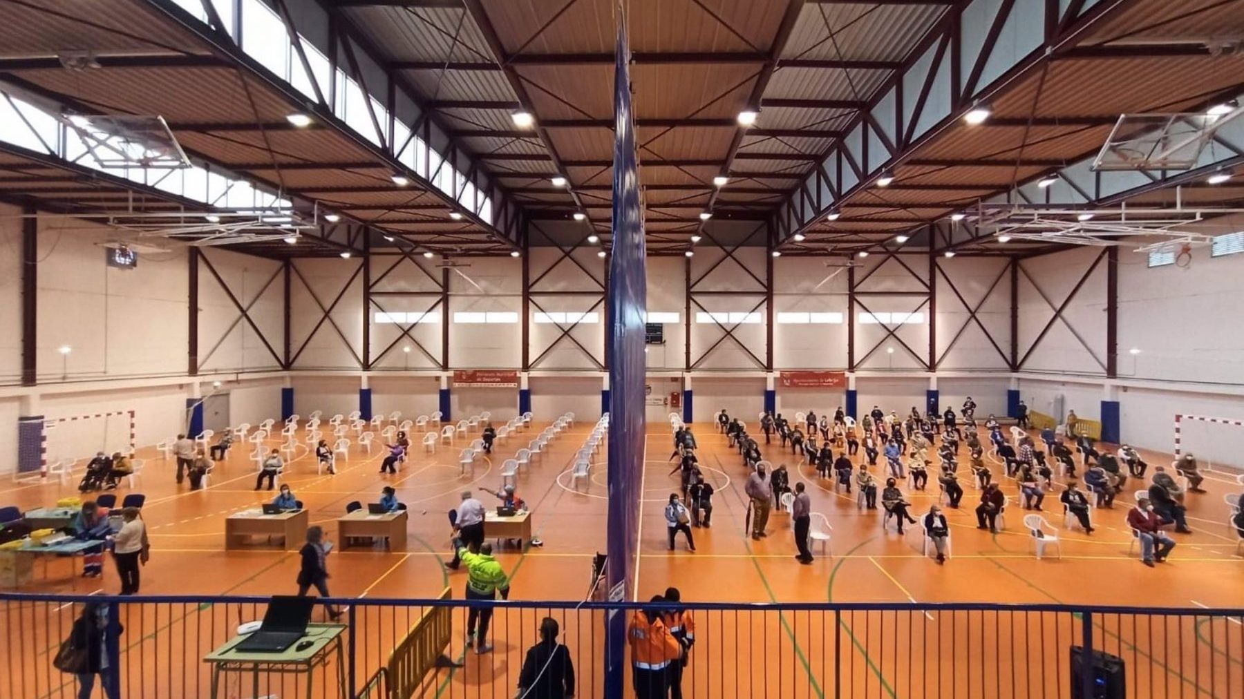 Personas recibiendo la vacuna en el pabellón municipal de deportes de Lebrija, en Sevilla (JUNTA DE ANDALUCÍA).