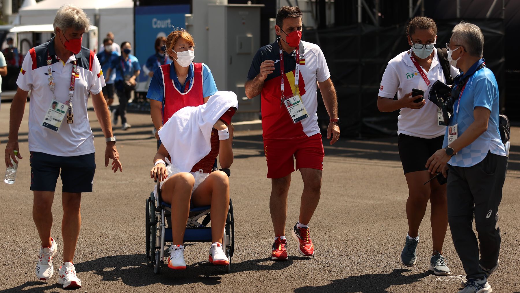 Paula Badosa, en silla de ruedas, acompañada de su equipo. (Getty)