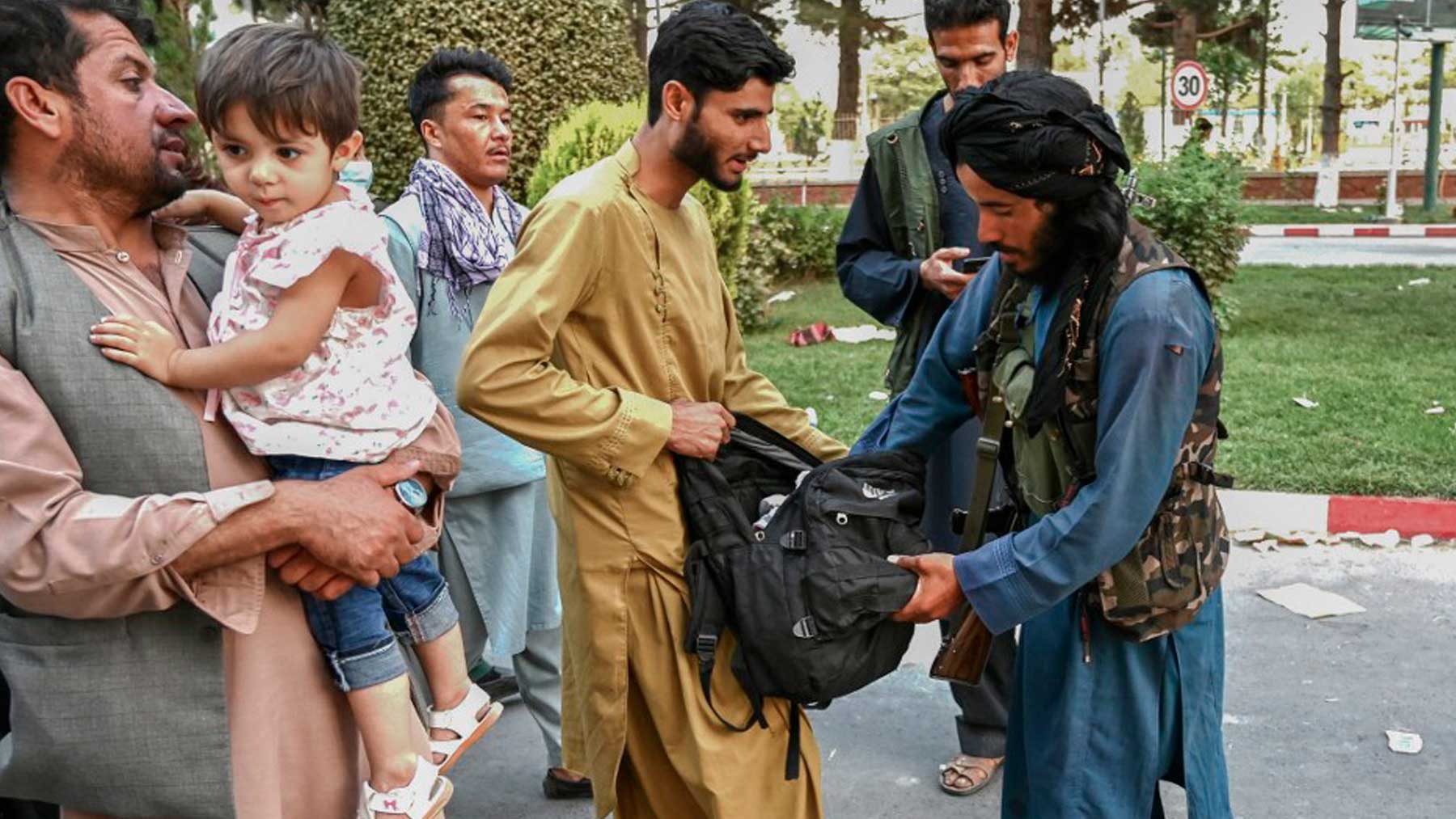 Un talibán registra a un ciudadano en la entrada del aeropuerto de Kabul, capital de Afganistán. Foto: AFP