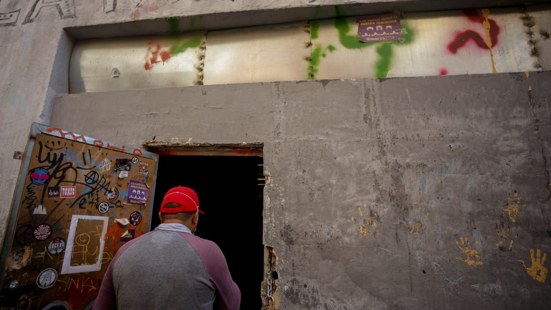 Una persona entra por la puerta de un local okupado (RICARDO RUBIO / EUROPA PRESS). (1) (1)