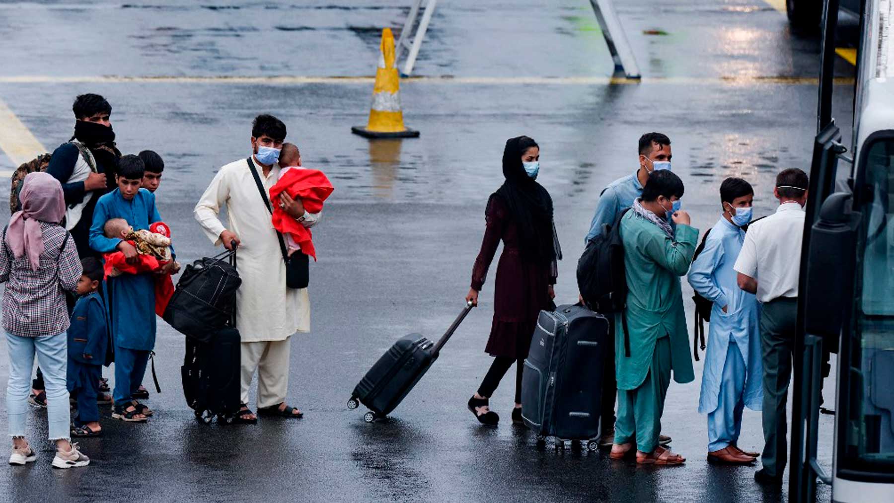 Ciudadanos afganos aterrizan en un aeropuerto de Bélgica después de ser evacuados de Kabul tras la llegada al poder de los talibanes. Foto: AFP