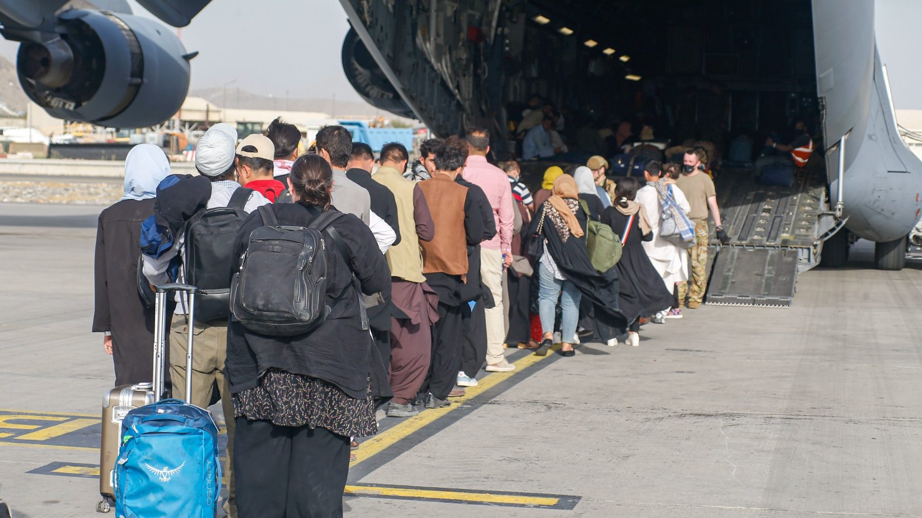 Afganos esperan a ser evacuados en un avión militar estadounidense en el aeropuerto de Kabul (NICHOLAS GUEVARA / DPA). (1)