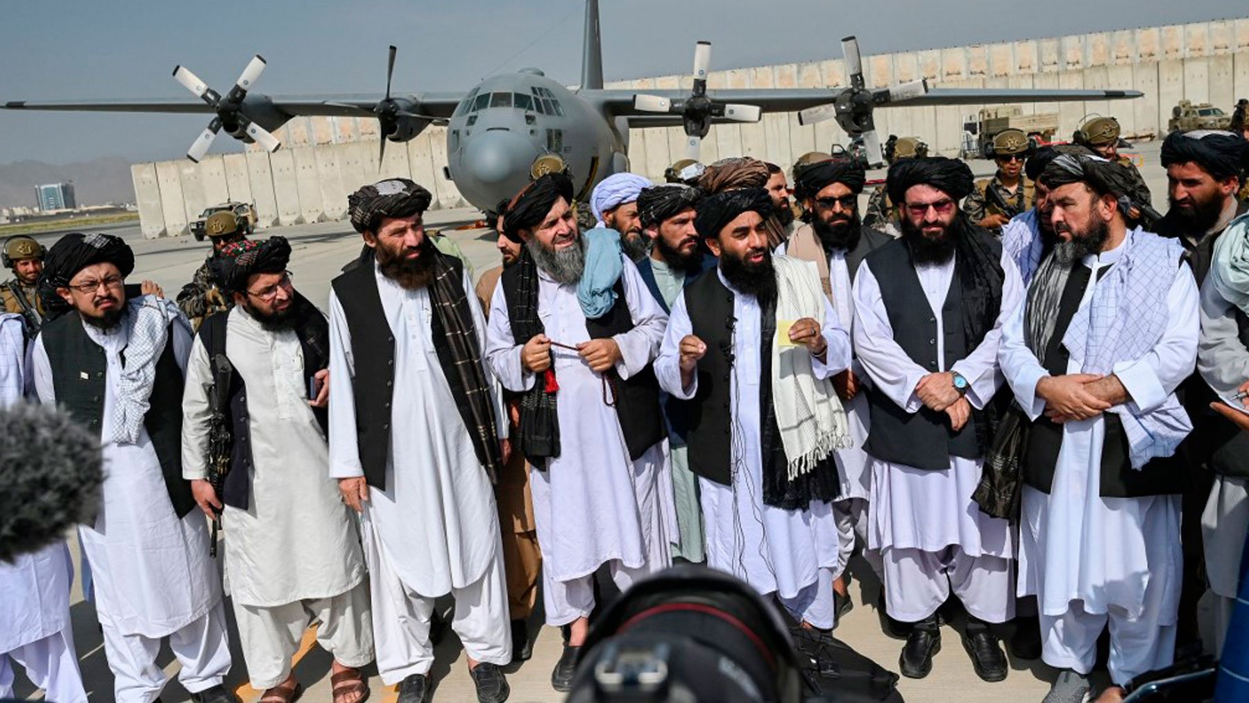 El portavoz talibán, Zabihulá Muyahid, con un grupo de talibanes en el aeropuerto de Kabul tras abandonarlo EEUU. Foto: AFP