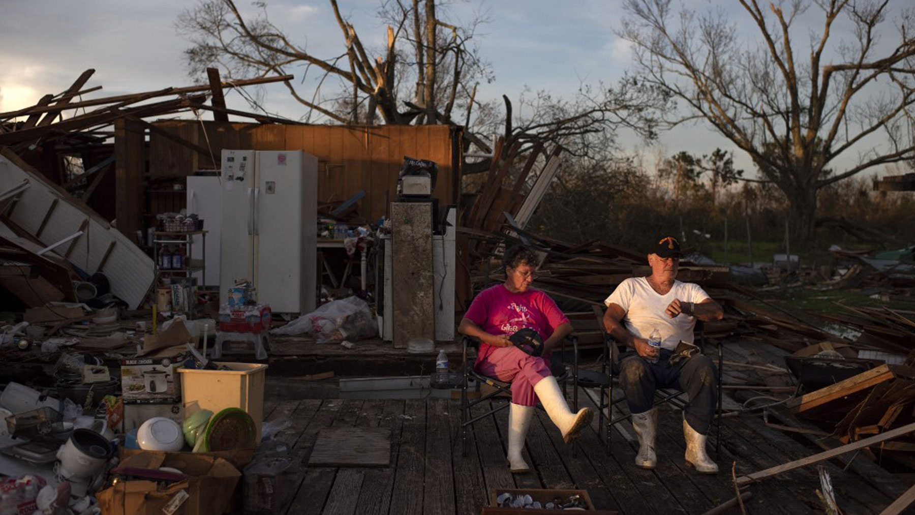 Darlene and Grant Dupre sentados frente a la que era su casa, antes del paso del huracán ‘Ida’, en Pointe-Aux-Chenes, estado de Luisiana. Foto: AFP