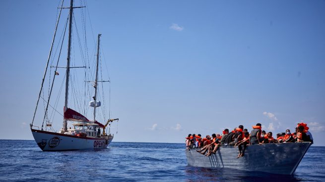 Un barco de Open Arms, junto a una patera (JESÚS HELLÍN / EUROPA PRESS).