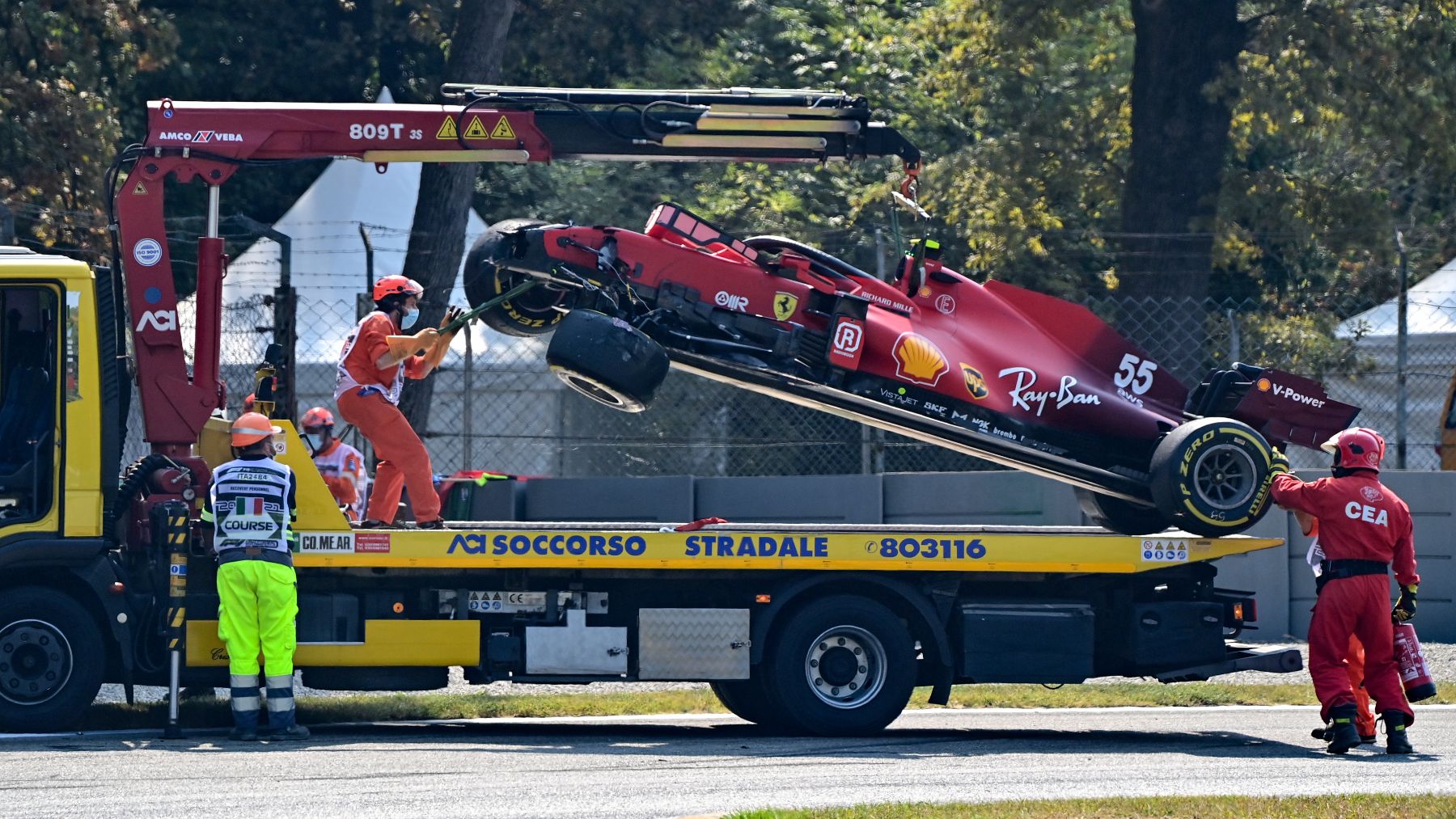 Los operarios retiran el Ferrari de Carlos Sainz tras su accidente en Monza. (AFP)