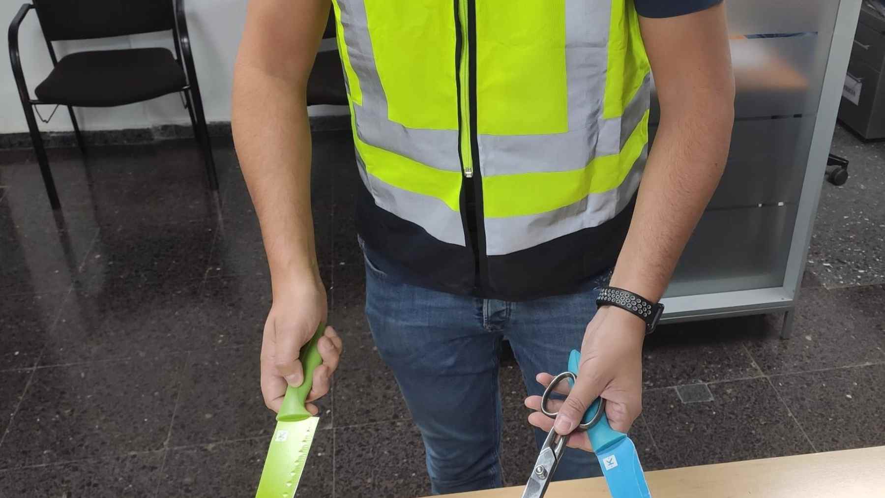 Un agente con el cuchillo y las tijeras intervenidas al detenido.